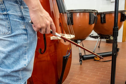 Real life young music students during rehearsals. Musical instruments and music stand with stave. Violin, drums, viola, flute