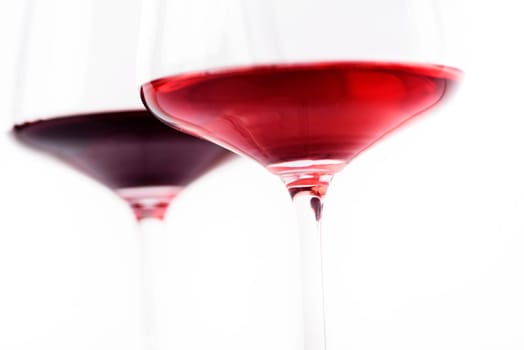Closeup of two glass of red and rose wine isolated over white background. Wine list menu design with copyspace. Wineglasses with luxury wines for wine tasting.