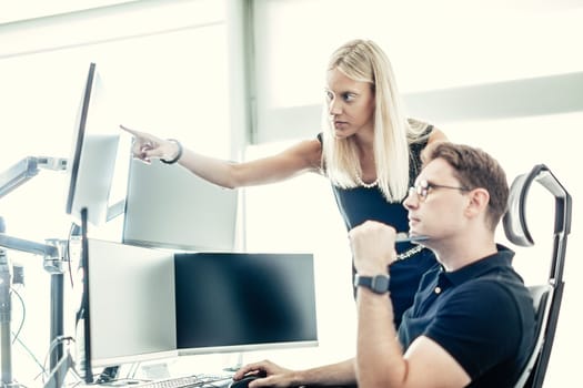 Stock broker business team trading online watching charts and data analyses on multiple computer screens in modern corporate work station office