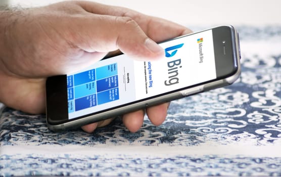 Redmond, US, Feb 28 2023: A hand holding a phone with the Microsoft Bing website on the screen. Bing is a search engine recently integrated with AI chatbot