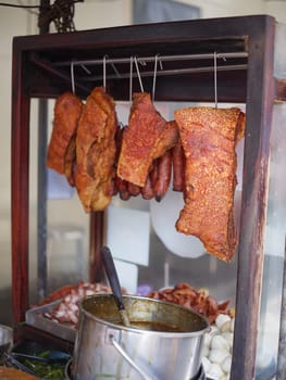 Barbecued red pork and crispy pork  in street food market .