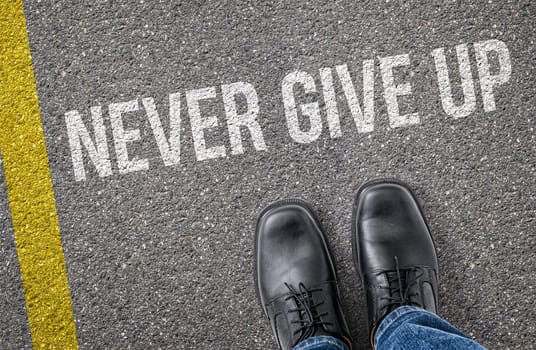 Text on the road - Never give up