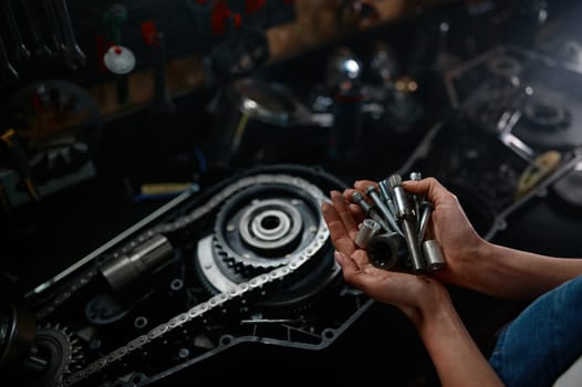 Different work tools and spare parts in female hands closeup shot with view from above. Repair store or cycling workshop