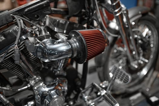 Closeup motorcycle to be repaired in mechanic workshop. Motorbike professional expertise, diagnostic and restoration