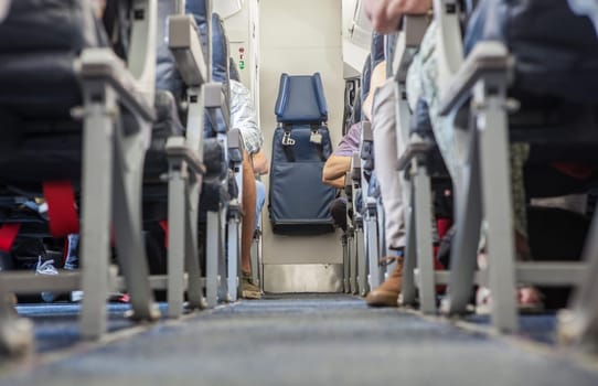 Normal class passenger jet airliner corridor. Tail stewardess seat