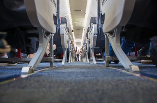 Normal class passenger jet airliner corridor. Ground view