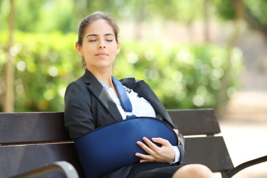 Convalescent businesswoman resting sitting on a bench in a park
