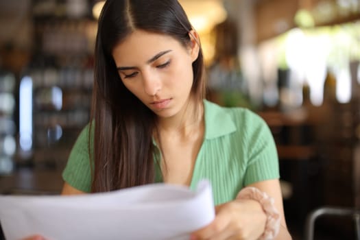 Attentive restaurant customer reading menu or document