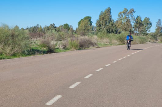 MTB Cyclist speeding down by local road. Vegas Altas irrigation channel roads