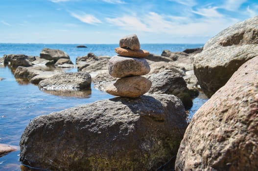 Stone pyramid on the coast of the Baltic Sea overlooking the sea in the sunshine. Spiritual view. Landscape shot from Poel island
