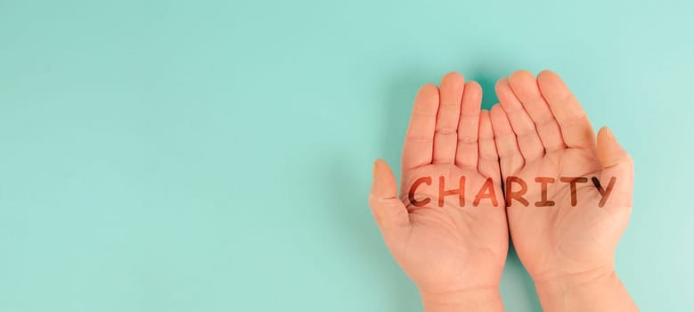 Hands with the word charity, support and help concept, social issue, humanitarian aid
