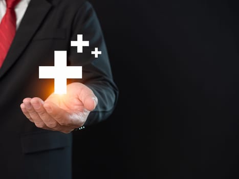 Businessman hold in hand offer positive thing such as profit, benefits, development, CSR represented by plus sign, healthcare insurance.The hand shows the plus sign.