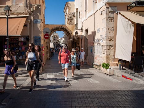 Rethymnon, Crete, Greece - June 16, 2022: The narrow street in Old Town of Rethymnon  where there are a lot of small cafes and shops