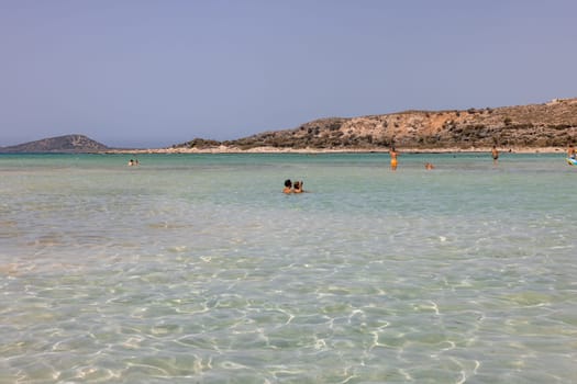 Elafonisi, Crete, Greece - Sept 19, 2021: People relaxing on the famous pink coral beach of Elafonisi on Crete, Mediterannean sea, Greece