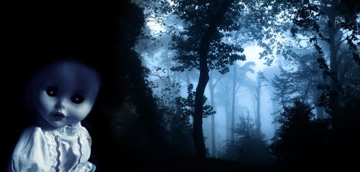 Vintage evil spooky doll and mysterious landscape of foggy forest