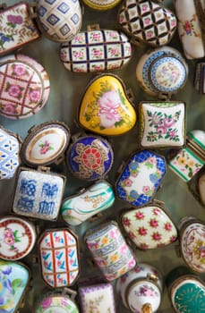 Barcelona, Spain - Jun 30th, 2023: Antique porcelain boxes or pillboxes. Encants market, Barcelona, Spain