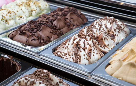 Display counter with assorted ice cream flavours. Selective focus