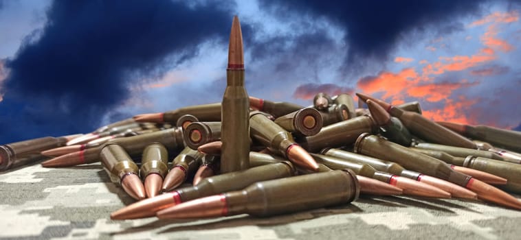 Cartridges for the Kalashnikov assault rifle. War Concept. Pile of cartridges with bullets. Means of killing. Ammunition for Kalashnikov assault rifle. Heap of billets