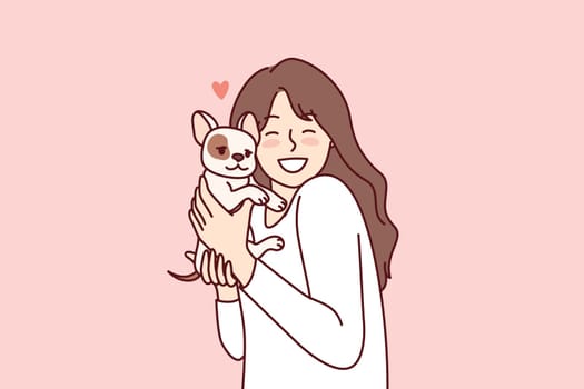 Little girl hugs puppy given for birthday and rejoices at dog become best friend for child. Happy female teenager with miniature dog enjoys interacting with cute pet adopted from shelter