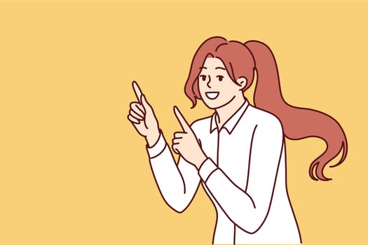 Woman smiles and points finger at copy space, recommending pay attention to interesting promo offer. Positive girl joyfully points in side giving advice to follow advertisers link.