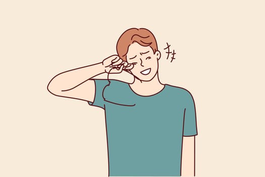 Laughing man takes off glasses wiping tears of joy from eyes after hearing joke or good news. Laughing young guy crying with happiness learning about salary increase or wife pregnancy