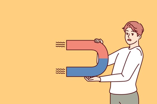Worried man with magnet looks scared at screen for concept of trying to attract customers to company. Confused guy with magnet symbolizing unsuccessful marketing strategy for advertising business