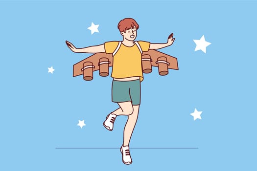Little boy dreams of becoming pilot or astronaut and jumps in suit with airplane wings. Cheerful teenager imagines that became professional pilot and went to fly through starry sky