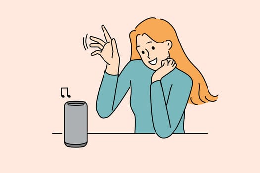 Woman uses wireless speaker with voice control to listen to music or communicate with virtual interlocutor. Wireless speaker for smart home and IOT technology near young smiling girl