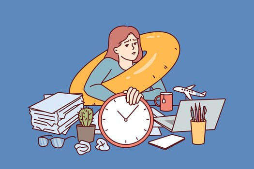 Sad woman freelancer dreams about travel and sits at office desk with inflatable swim ring around neck. Businesswoman is frustrated because of long absence of summer vacation and wants to go to travel