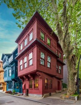 Facade of colorful wooden residential buildings painted in red and blue, with wrought iron window, at an alley suited in Kuzguncuk neighborhood, Uskudar district, Istanbul, Turkey