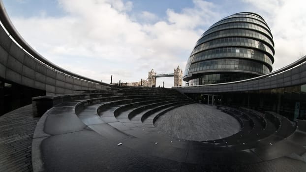 London, United Kingdom - February 10, 2007: Extreme wide (fisheye) photo, City hall and Tower bridge as seen from The Scoop (nearby sunken amphitheatre)