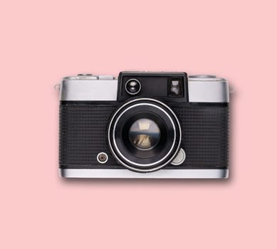 vintage old film camera on pink background with shadow