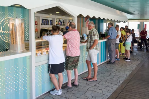 Catania, Italy -February 18, 2025: An ice cream shop with customers queuing at the counter. It is an outdoor terrace with a relaxed summer atmosphere. Concept: gastronomic experience, Italian culture.