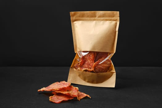 Portion of spicy jerky pork meat in paper package