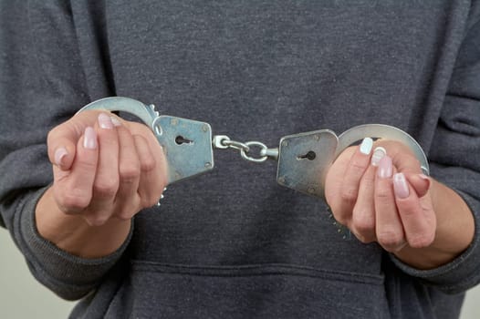 women's hands are handcuffed in close-up. High quality photo
