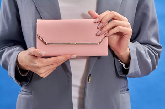 Women's hands hold a pink purse. High quality photo