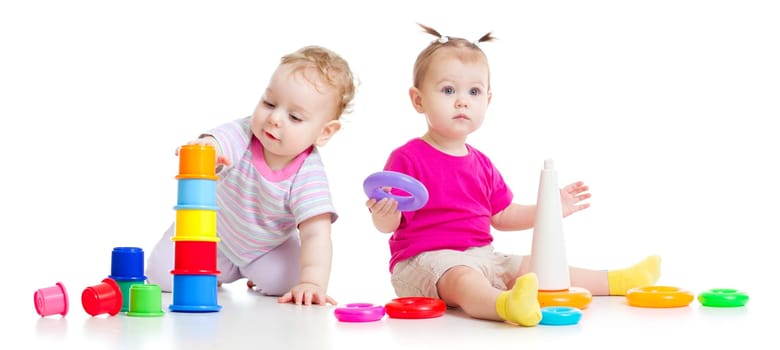 Adorable kids playing with colorful towers isolated on white