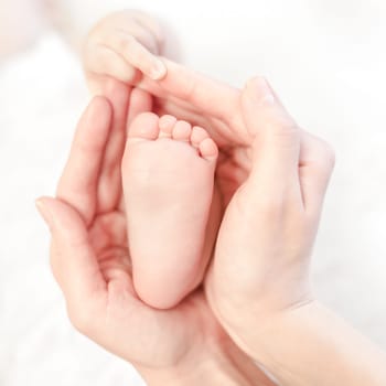baby foot in mother's careful hands