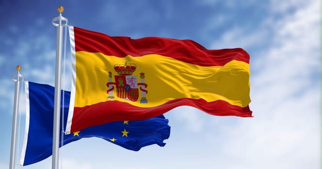National flag of Spain waving with the European Union flag in the background on a clear day. International cooperation 3d illustration render. Fluttering fabric
