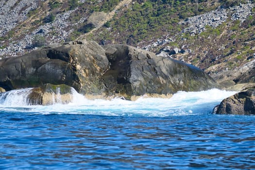 norway on the fjord, spray on rocks. Water splashes on the stones. Coastal landscape in Scandinavia. Landscape photo from the north
