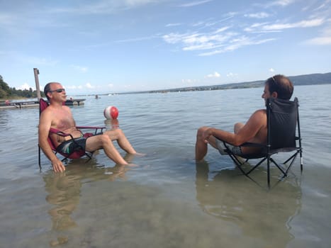 Theme picture Summer - Summer day at Lake Constance  This is how it can be endured on the hottest day of the year so far and not just cooling off for the feet: Despite the summer heat,these two men have positioned their sitting chair right next to Allensbach in Lake Constance and thus find the right cooling not only for their feet.  Young and old sought to cool off on a boat trip,an excursion with the Stand Up Paddle (SUP) or while swimming. The next few days are expected to remain hot in summer if thunderstorms are likely to occur