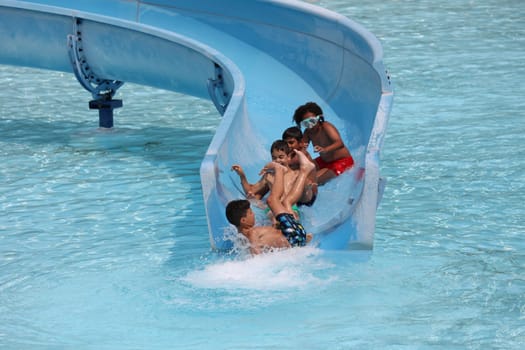 Theme picture summer -   The dog days are here - people crave to cool off at temperatures above 30 degrees Celsius,like here in the lido of Freiburg im Breisgau. The children have great fun on the water slide