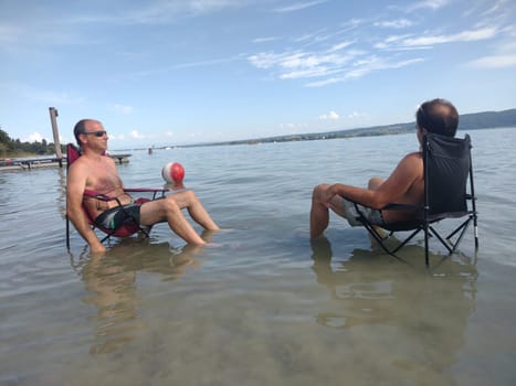 Theme picture Summer - Summer day at Lake Constance  This is how it can be endured on the hottest day of the year so far and not just cooling off for the feet: Despite the summer heat,these two men have positioned their sitting chair right next to Allensbach in Lake Constance and thus find the right cooling not only for their feet.  Young and old sought to cool off on a boat trip,an excursion with the Stand Up Paddle (SUP) or while swimming. The next few days are expected to remain hot in summer if thunderstorms are likely to occur