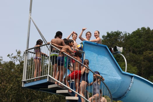 Theme picture summer -   The dog days are here - people crave to cool off at temperatures above 30 degrees Celsius,like here in the lido of Freiburg im Breisgau. The children have fun on the water slide and there is a lively crowd
