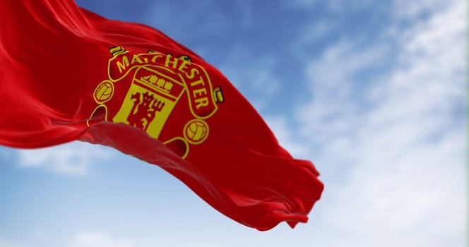 Manchester, UK, July 2 2023: Flag of Manchester United Football Club waving on a clear day. Premier League pro team. Illustrative editorial 3d illustration render. Selective focus