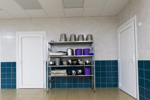 Industrial kitchen in school restaurant with professional equipment and pans