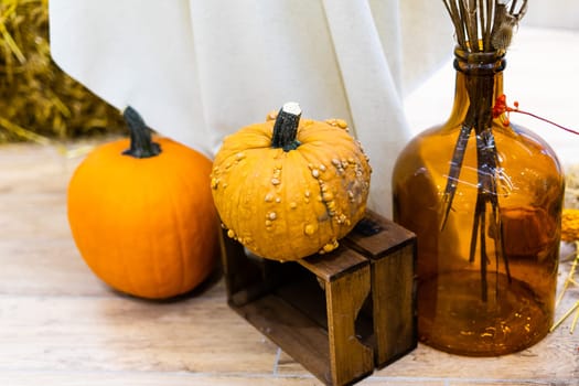 Ripe orange autumn pumpkins in wooden baskets with straw, hay bales farmers market for Halloween.