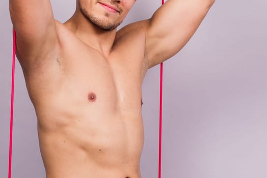 Fit young athlete preparing for a bicep muscle arms exercise. Isolated over grey studio background.