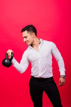 Attractive businessman Exercising With Kettlebell In a studio, red background