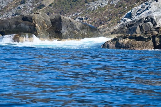 norway on the fjord, spray on rocks. Water splashes on the stones. Coastal landscape in Scandinavia. Landscape photo from the north